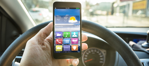 Driver checking his mobile phone while driving