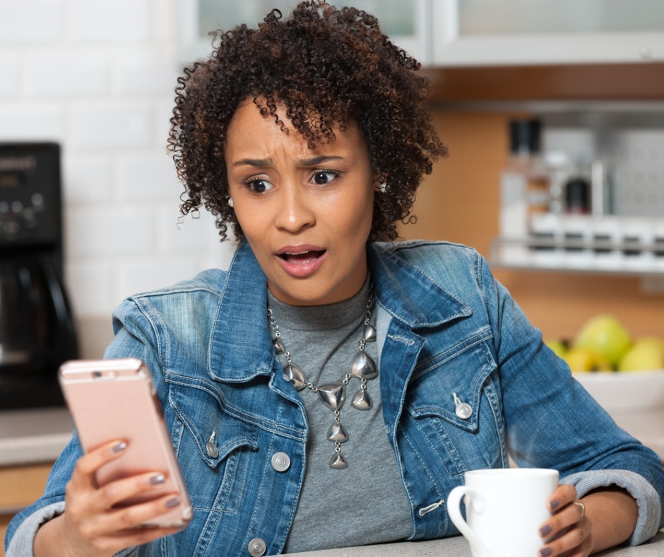 Photo of shocked woman looking at her mobile phone