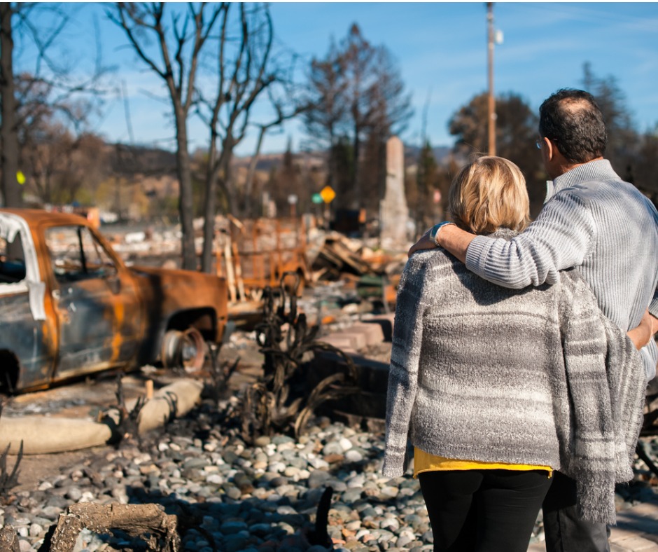 Photo of a couple viewing a home destroyed by fire