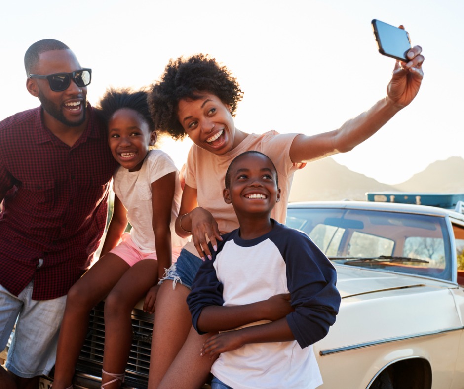 Photo of a family taking a selfie while on a road trip.