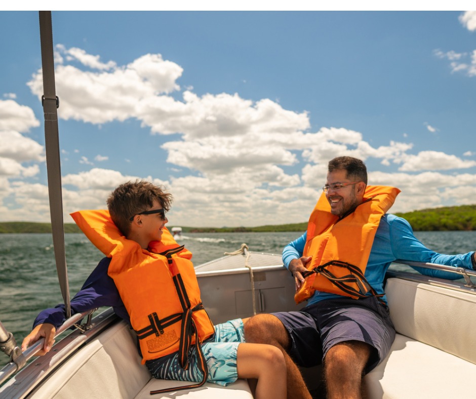 Photo of a Dad and his son wearing life jackets and enjoying a ride in a speedboat.