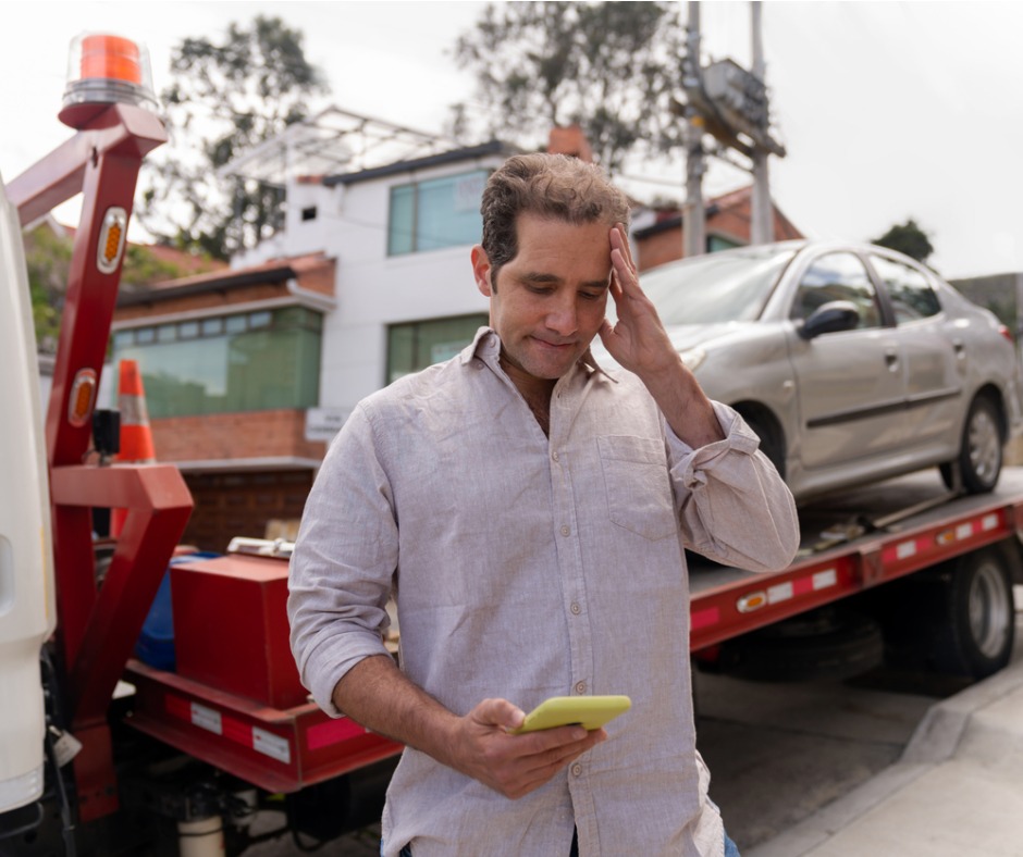 Photo of a man next to a tow truck calling for a ride