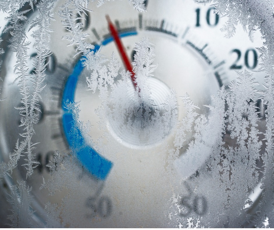 Photo of a round outdoor thermometer through a frosted window