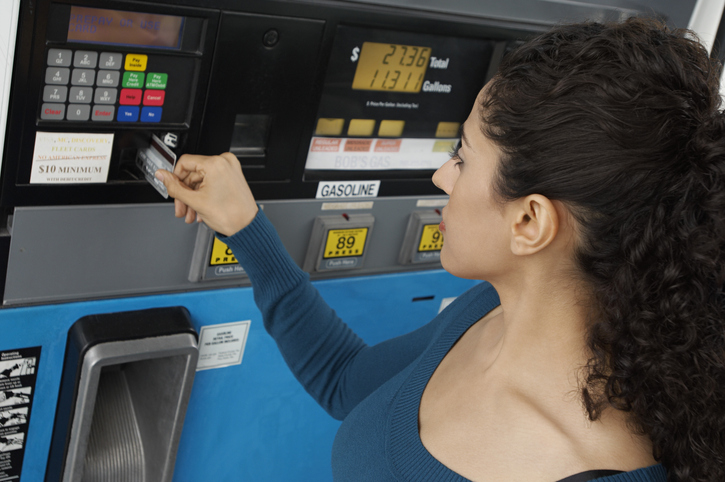 Photo of a woman paying at the gas pump