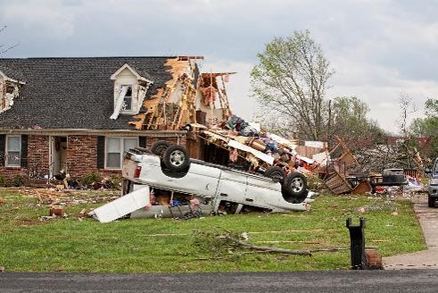 Photo of tornado damage to a home and vehicle