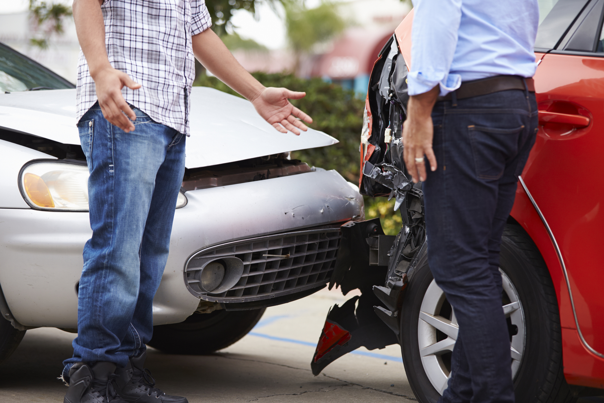 Photo of two people arguing at the site of a car accident.