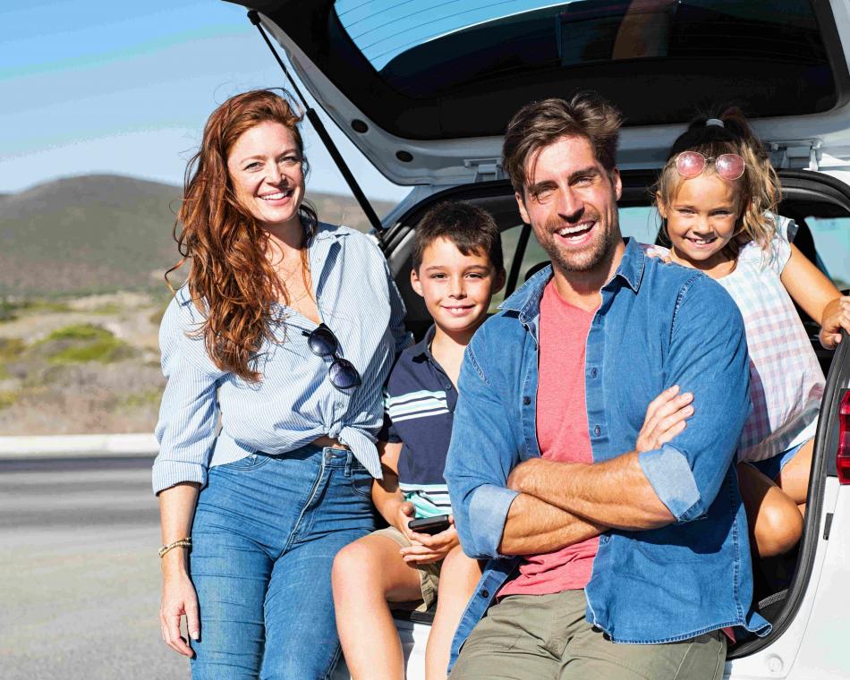 Young family with two children sitting in a open SUV