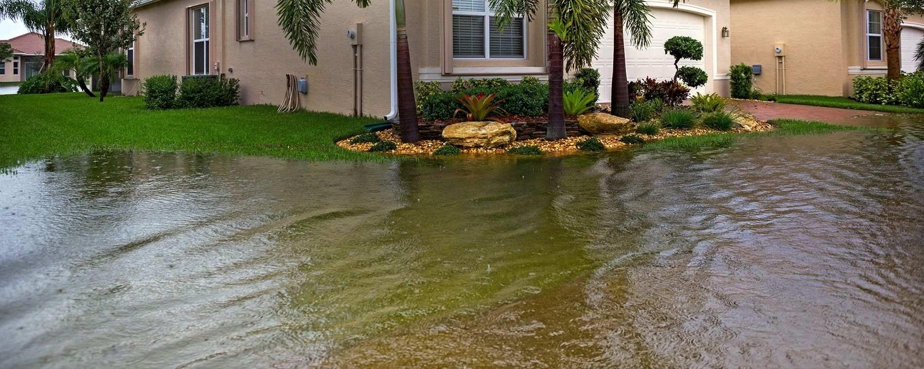 A newer home with flood waters approaching the foundation.